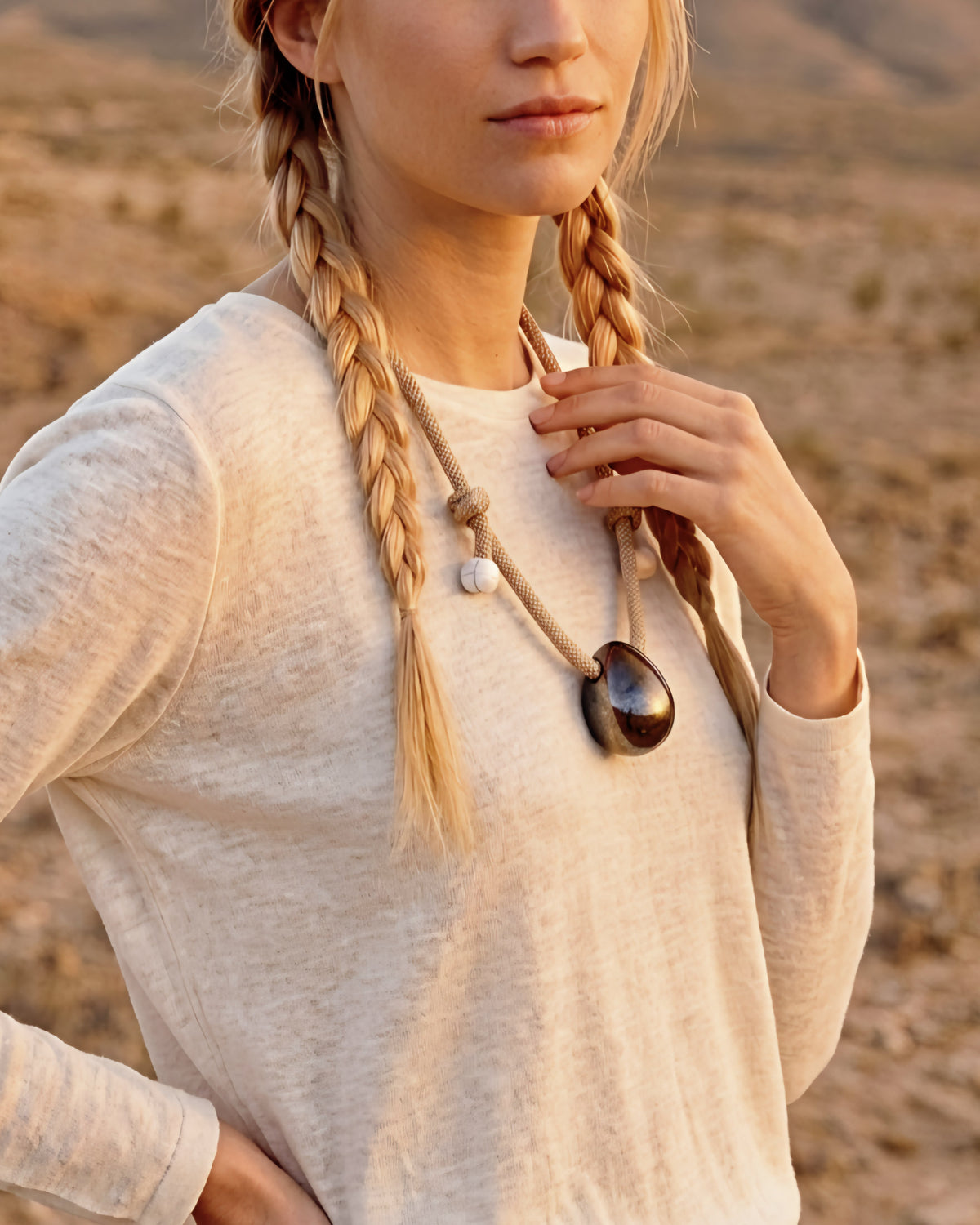Collana Uovo Cosmico – modella con trecce nel deserto