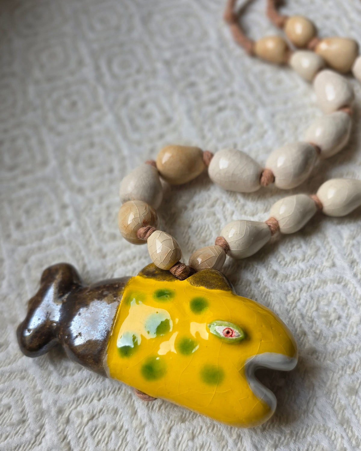 Collana Pesce Raro – il pesce di tre quarti, corpo giallo brillante a pois verdi, bocca spalancata bordata di bianco, occhio in rilievo, coda in bronzo metallico