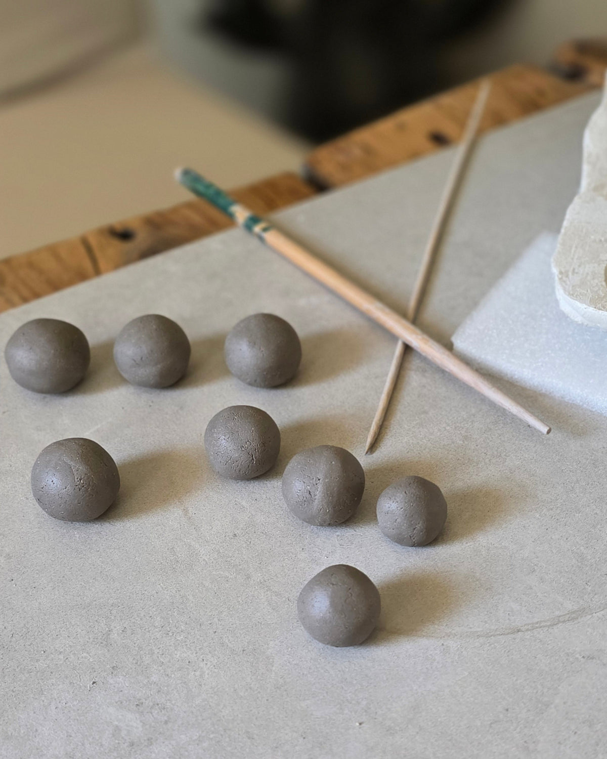 Collana Archeperla – Bianco – lavorazione — palline di argilla cruda sul banco