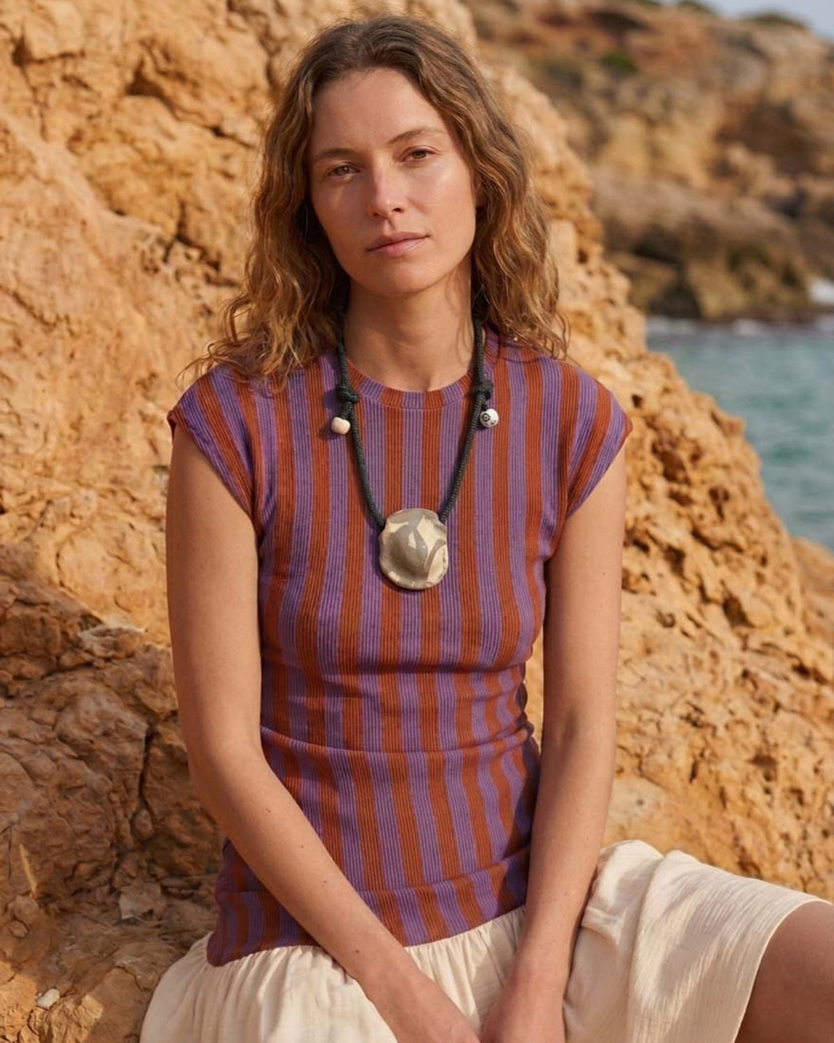 Collana Sogno – modella al mare con maglia a righe