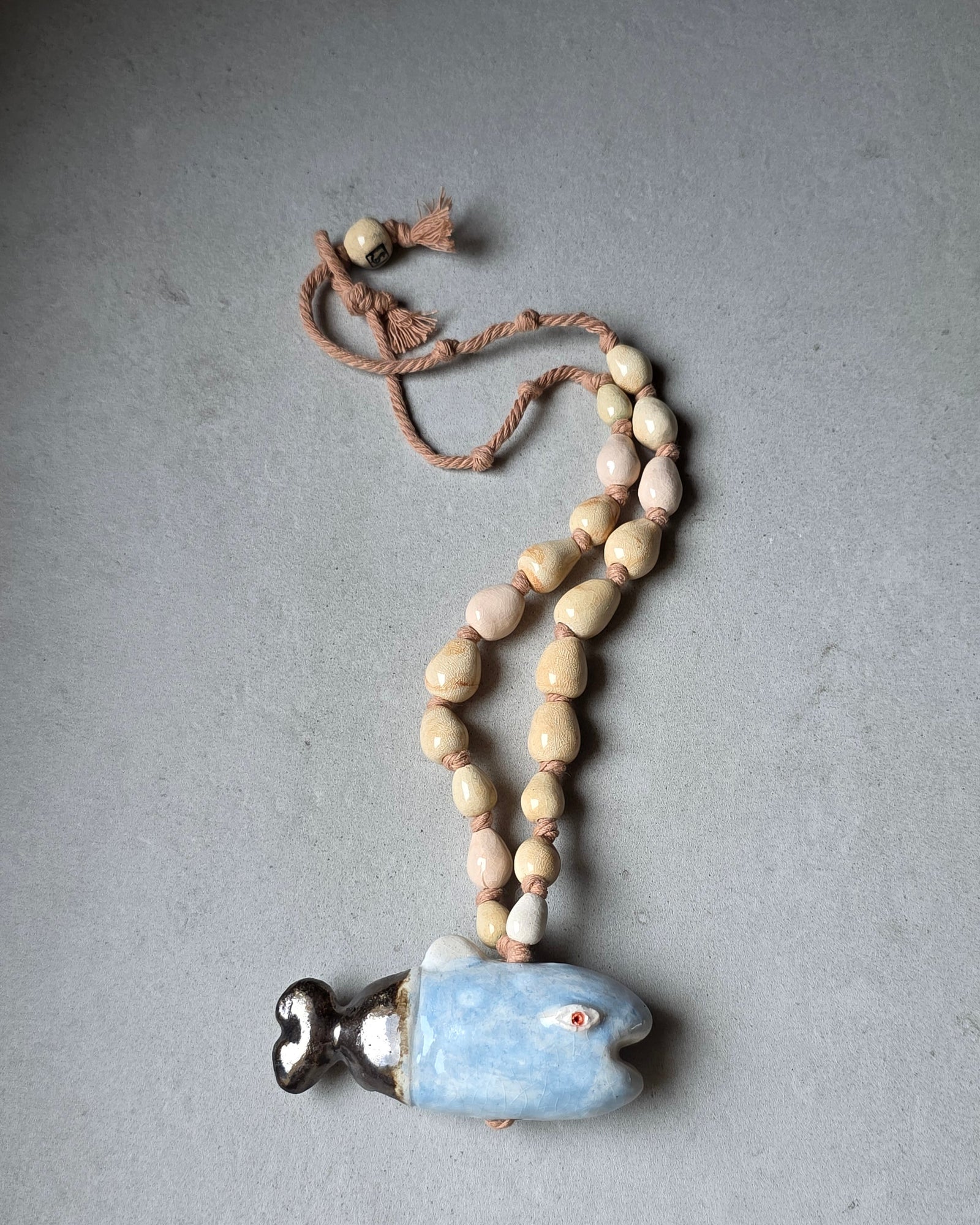 Collana Pesce Azzurro – la collana distesa in lunghezza, con il pesce in basso e la perla avorio SF in alto
