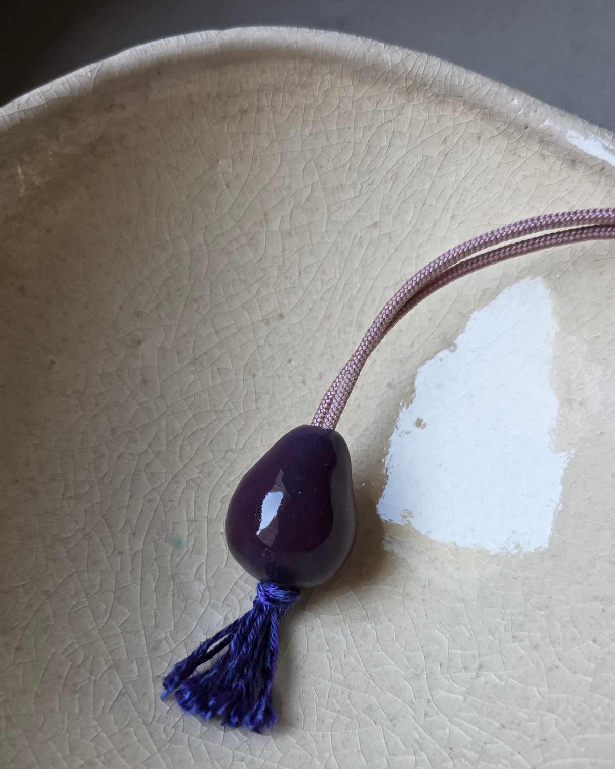 Collana Japamini – Viola – la collana intera sul piano grigio