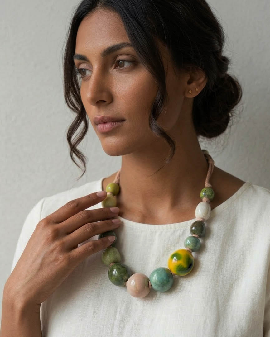 una bellissima donna indossa un' elegante collana di perle multicolore dalle forme organiche