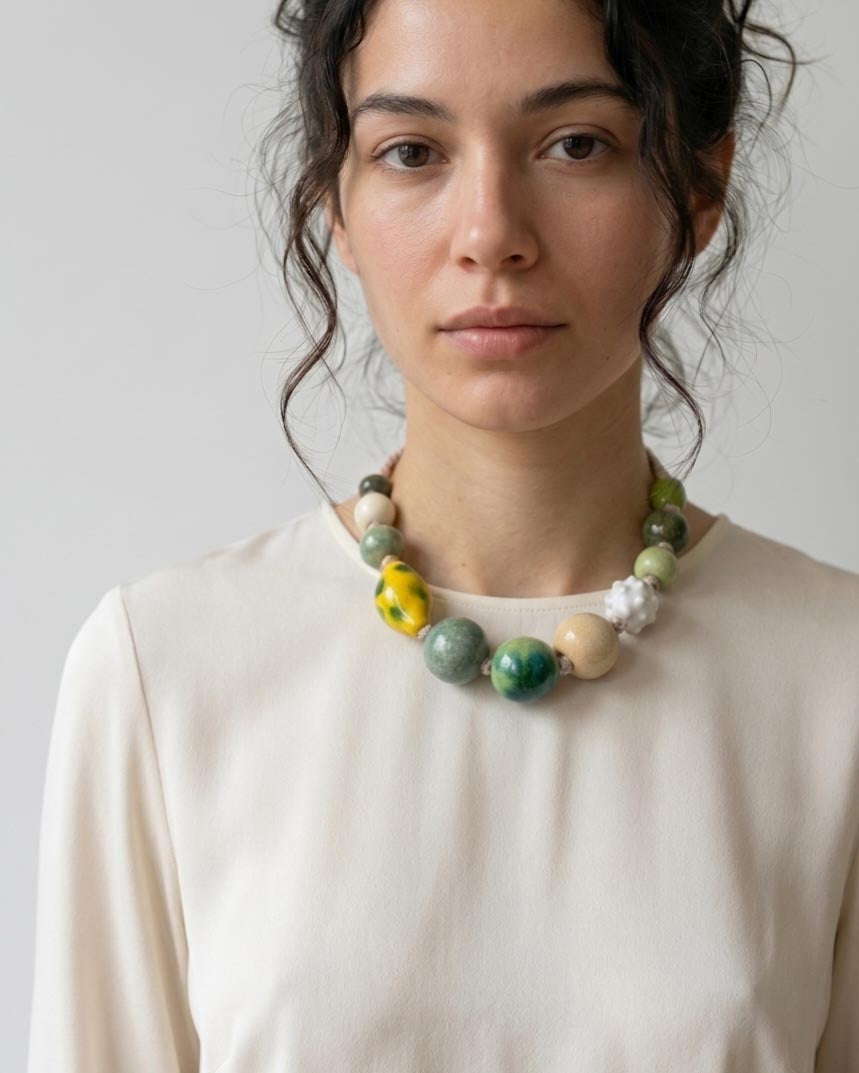 Donna che indossa collana di perle in ceramica sui toni del verde bosco