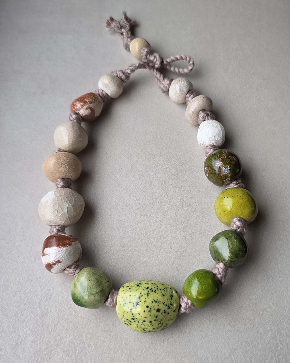 una collana dalle perle fatte a mano in ceramica, dalle forme irregolari e colori naturali