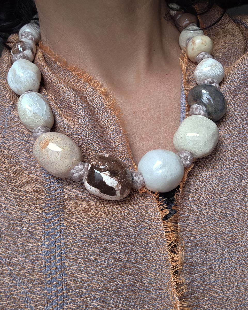una collana con grandi perle in ceramica colori neutri e di terra