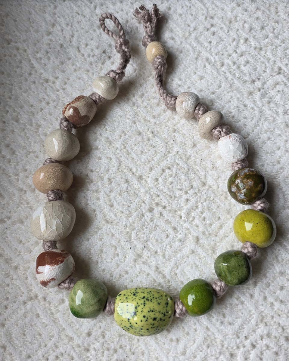 collana in ceramica con perle annodate dalle forme naturali, colori  neutri, muschio e fango