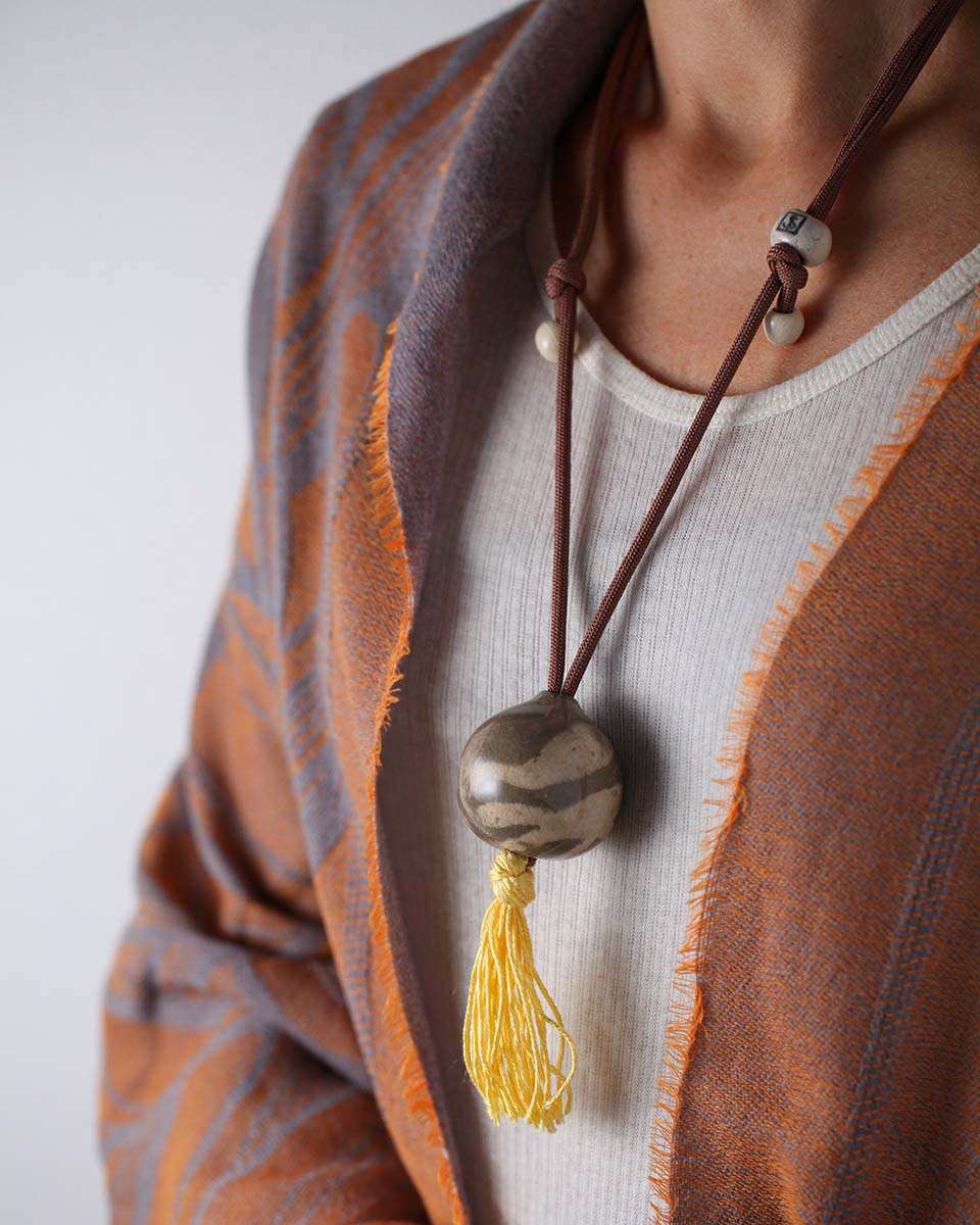 La collana in ceramica perla Nomade, color avorio e sabbia con nappina gialla